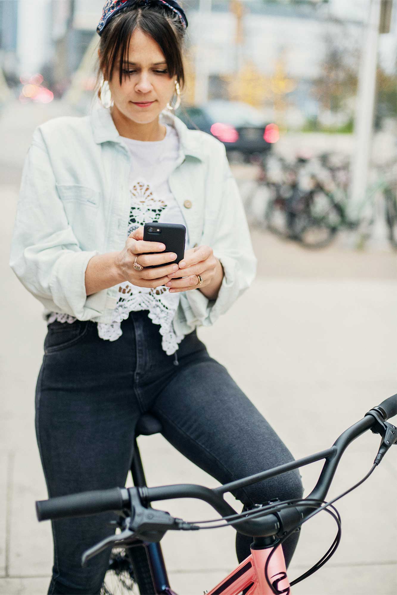 Karen Skloss on a bicycle holding a phone