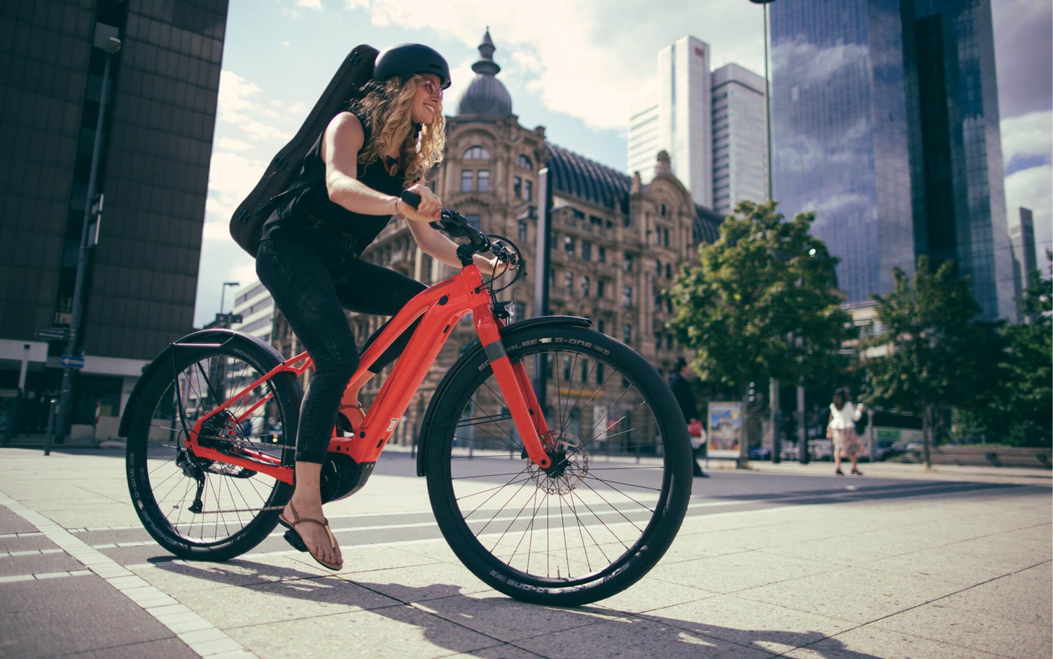 woman riding orange city e-bike