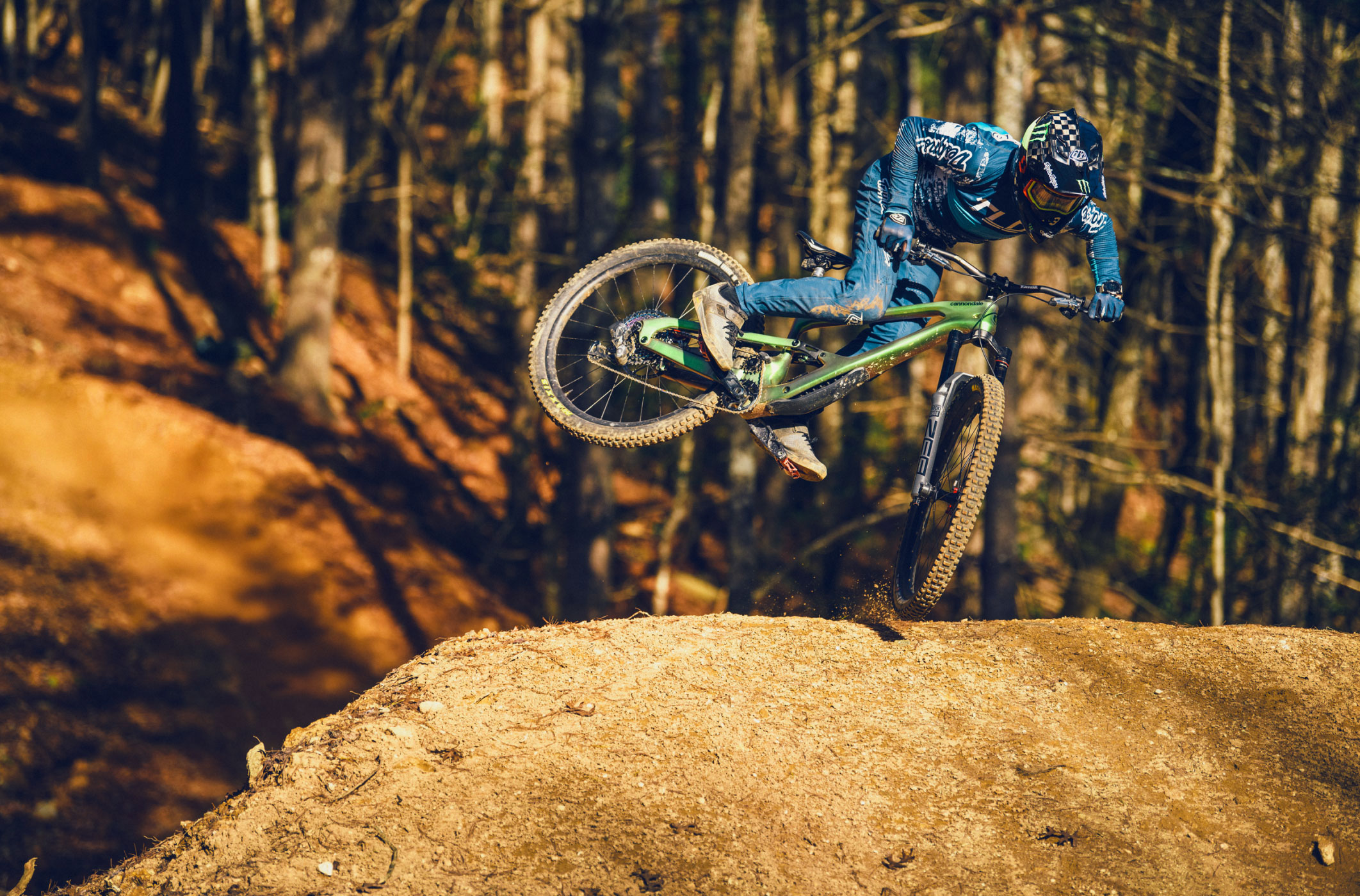 a person riding a bike on a dirt trail in the woods