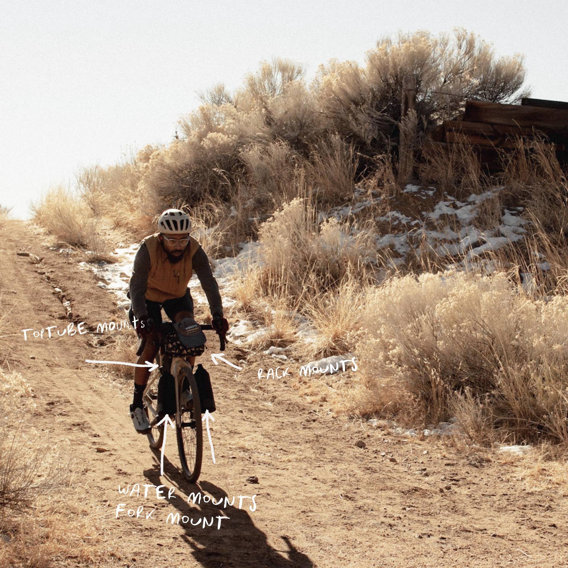 a man riding a bike on a dirt path in the desert